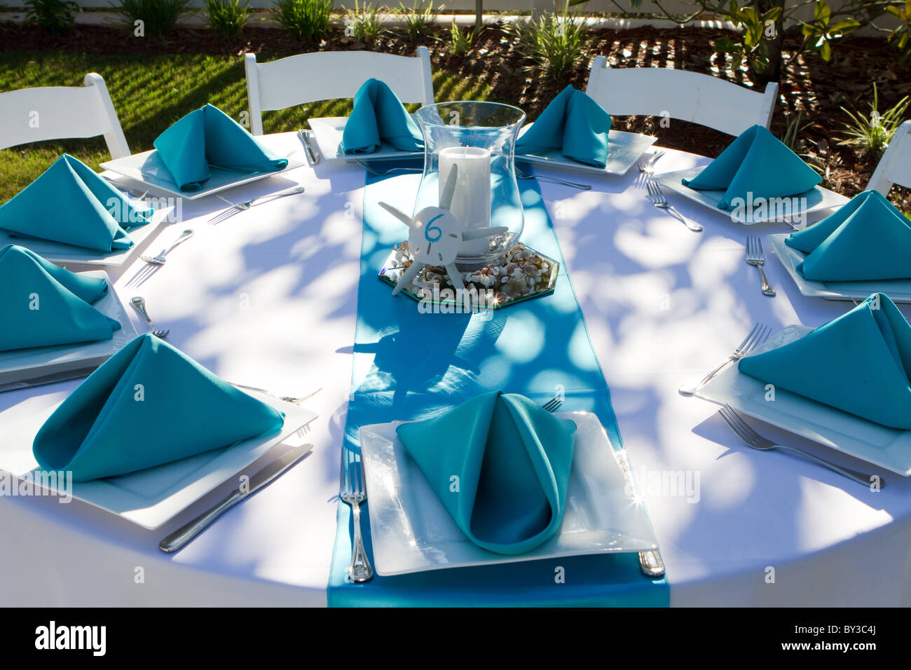 Outdoor Dinner Table Is Setup With Plate Silverware And Folded