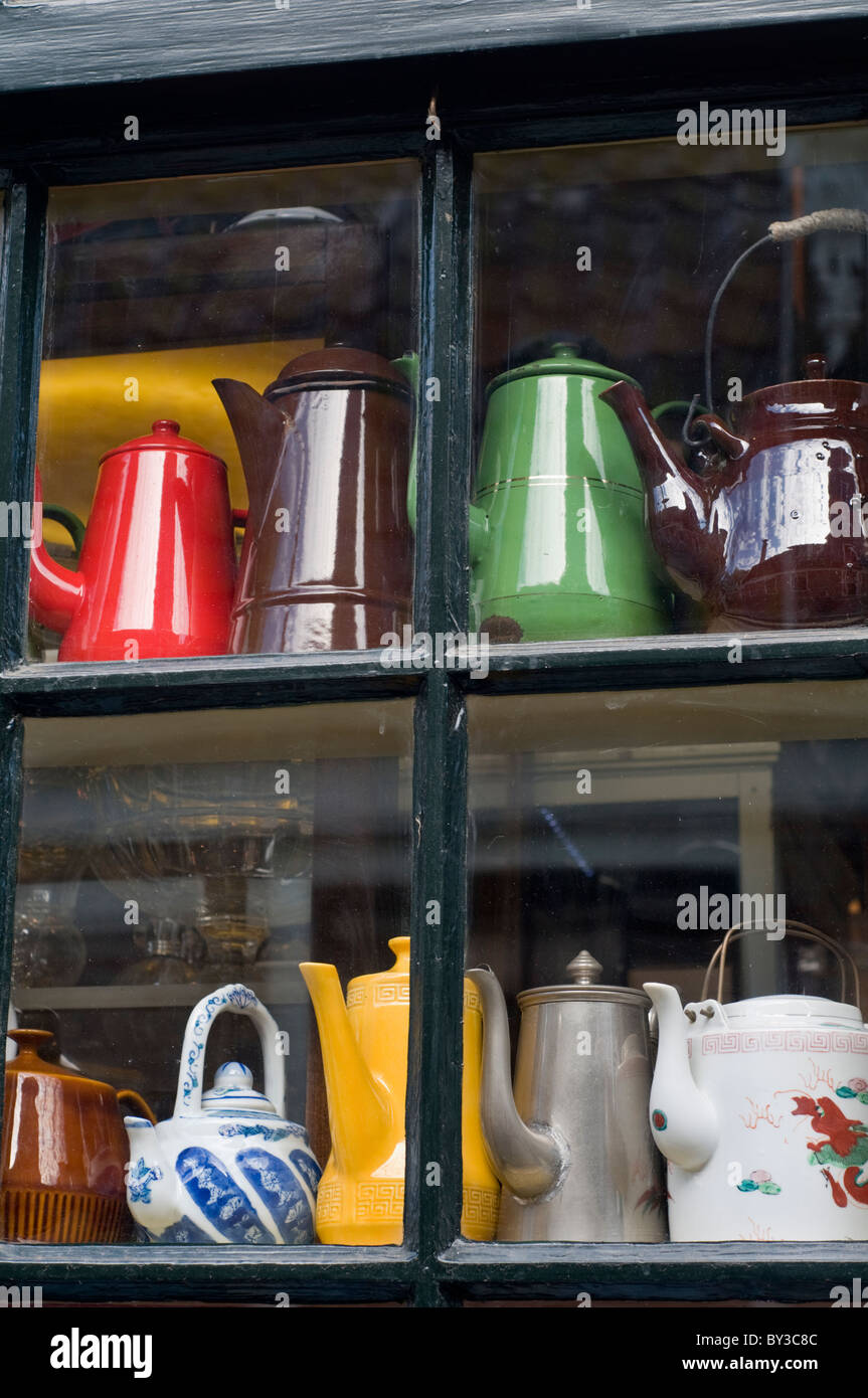 A variety of tea pots and kettles in the window of a traditional shop