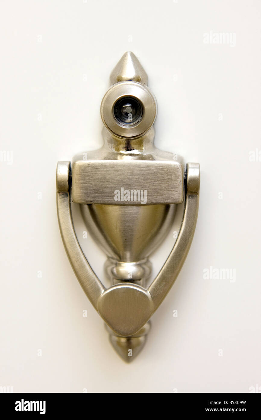 A brushed bronze door knocker installed with a built in peep hole. Stock Photo