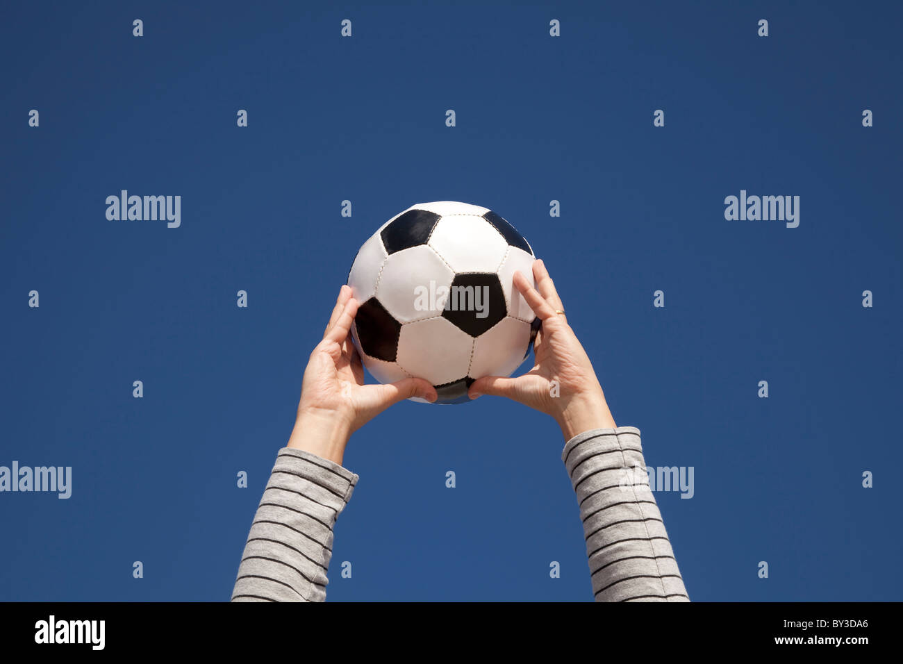 Hands holding a soccer ball up to the sky Stock Photo Alamy