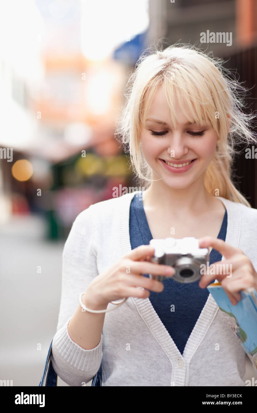 USA, Seattle, Smiling young woman holding digital camera Stock Photo ...