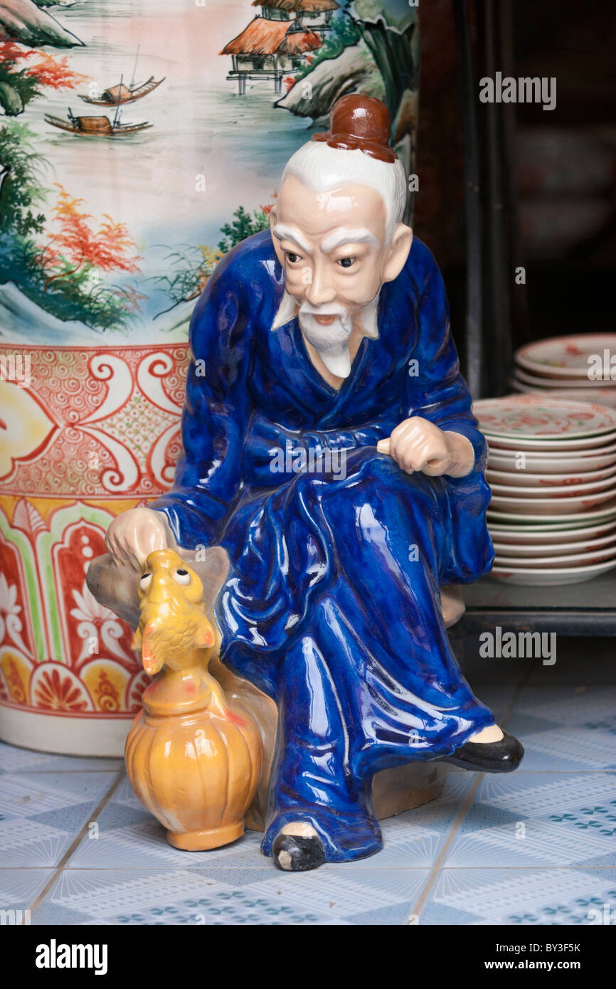 Ceramic figure of a philosopher or sage in a blue robe and a red hat Stock Photo