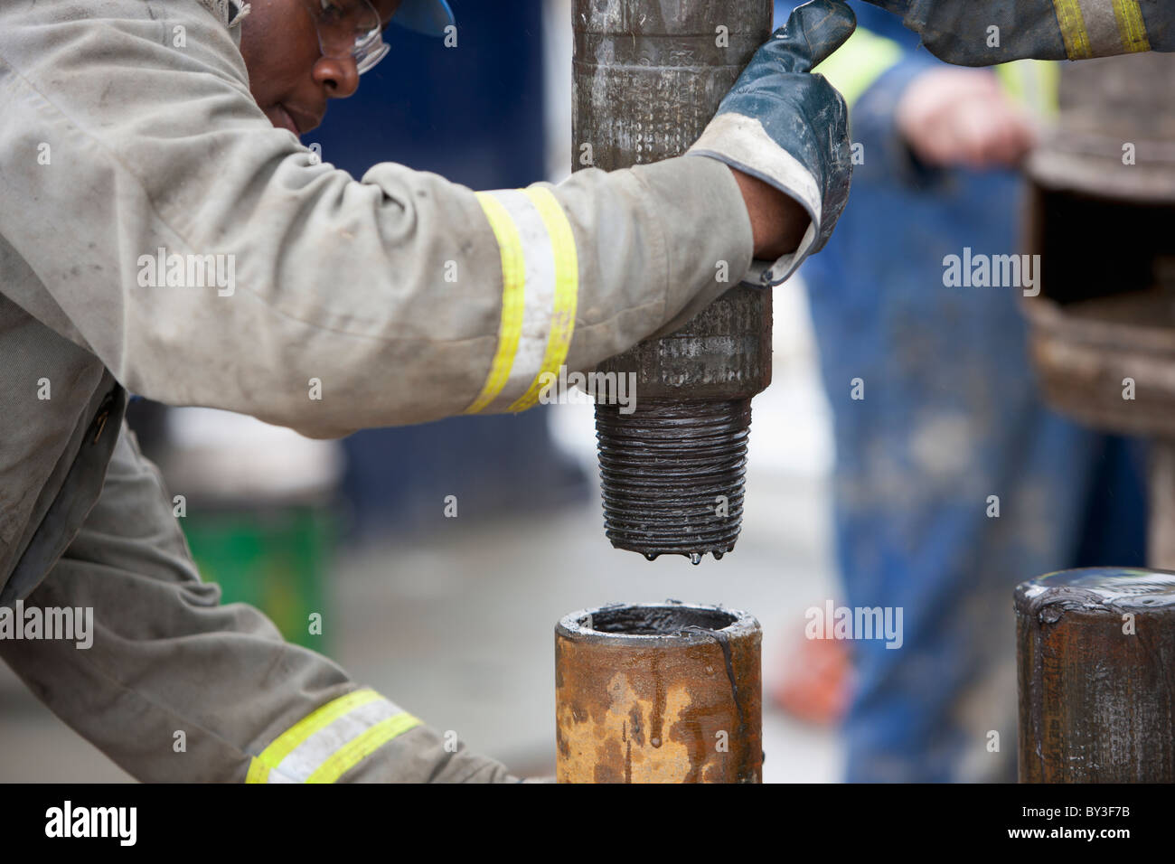 Oil worker drilling for oil on rig Stock Photo