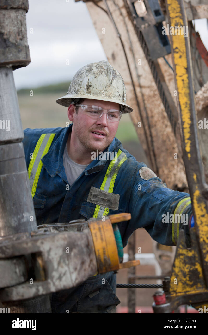 Oil worker drilling for oil on rig Stock Photo