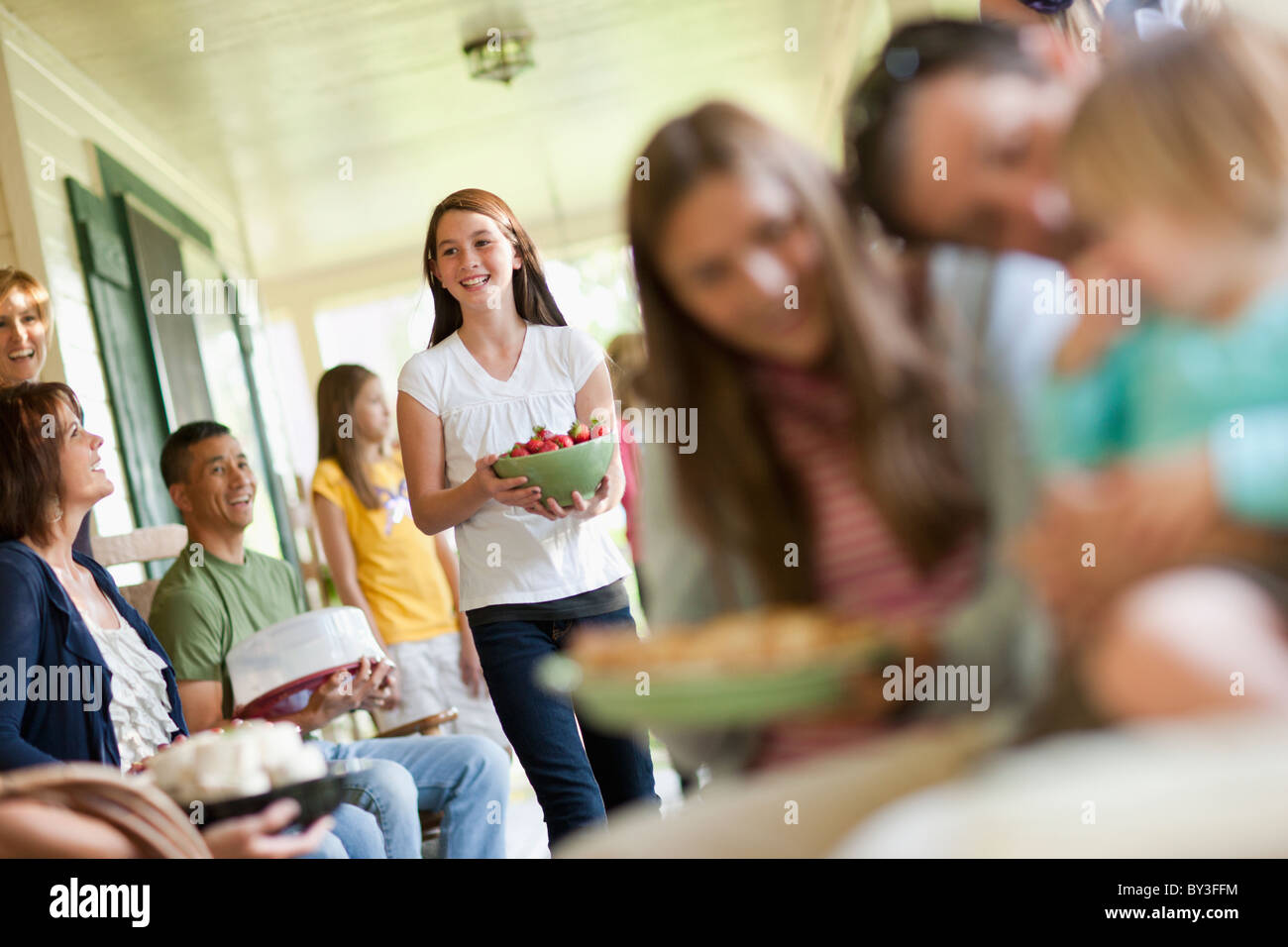 Girls (10-11, 2-3, 14-15) with father and family during celebration event Stock Photo