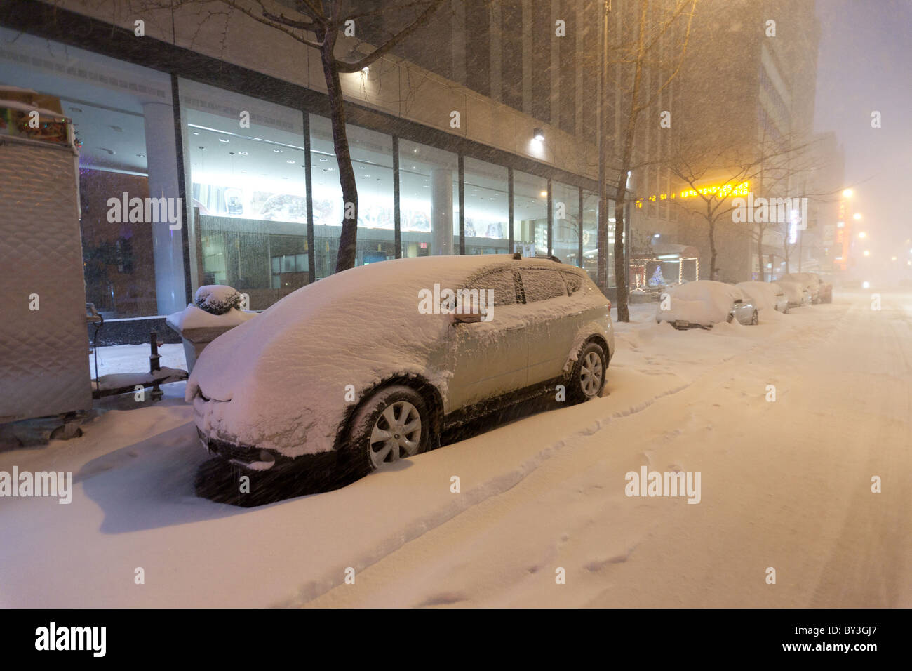 Cars parked alongside 43rd street covered in thick snow blanket in the