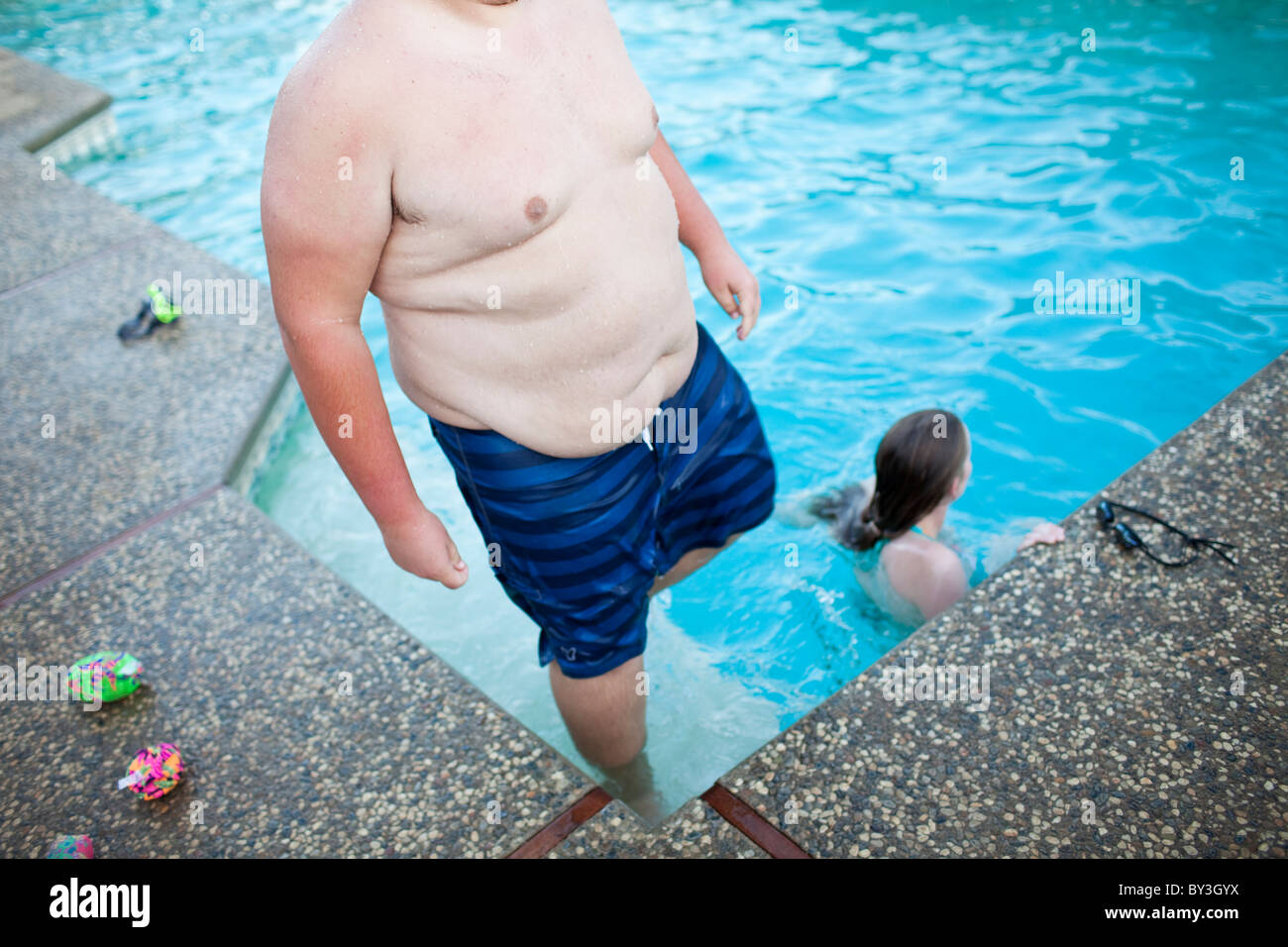 Hughson, California, United States.  An obese teenager steps out of a swimming pool. Stock Photo