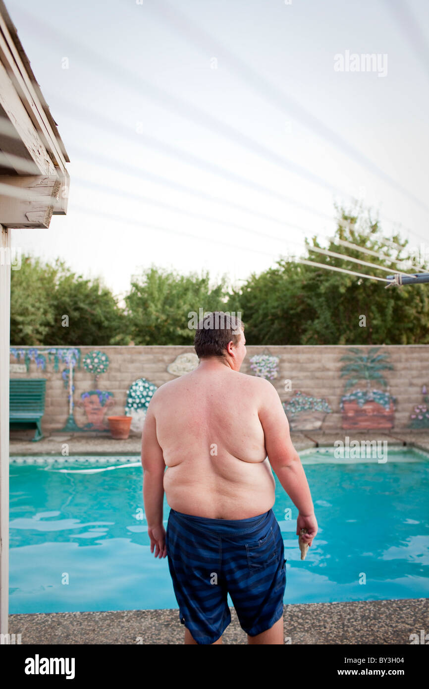 Hughson, California, United States.  An obese teenager hangs out by the swimming pool. Stock Photo