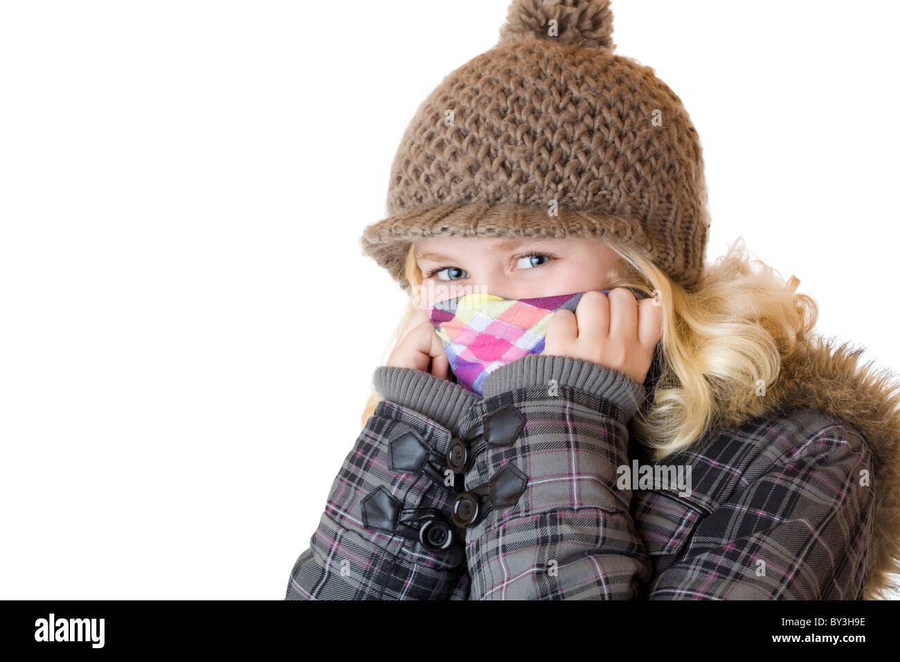 Young happy girl with cap, scarf and jacket. Isolated on white background. Stock Photo