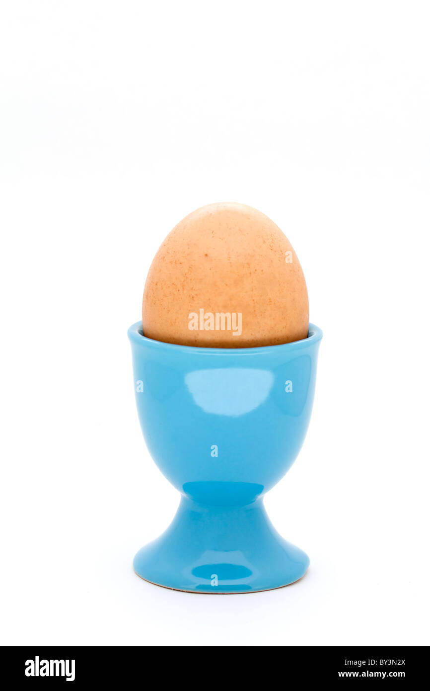 Egg in blue egg cup on white background Stock Photo