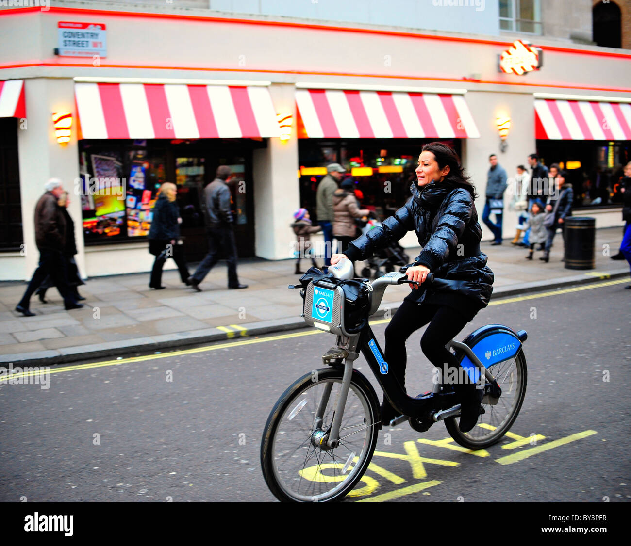 Women riding a hired bicycle (Boris bike) in London Stock Photo