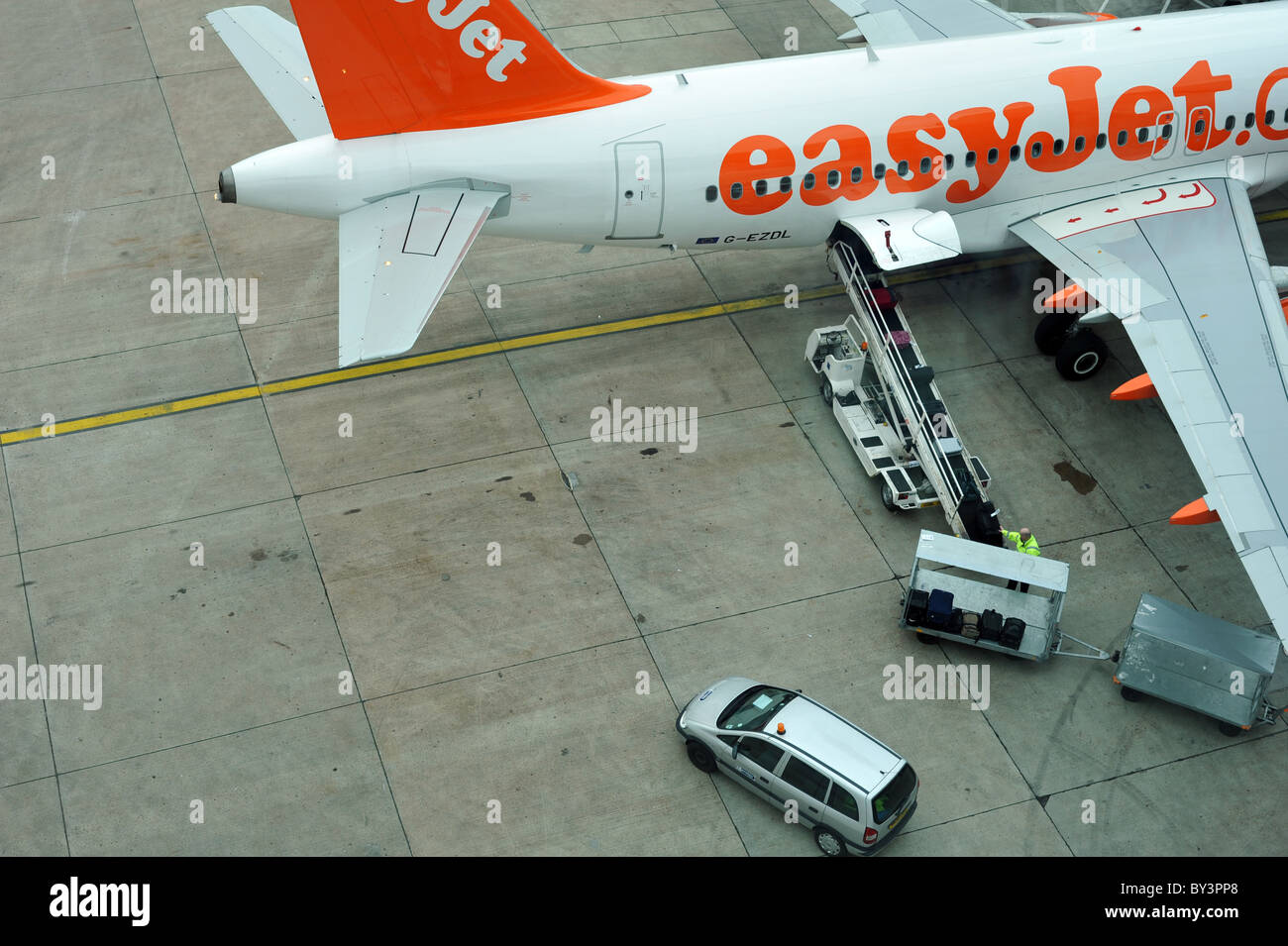 Baggage handlers loading hold luggage onto an aircraft - Gatwick, UK Stock Photo