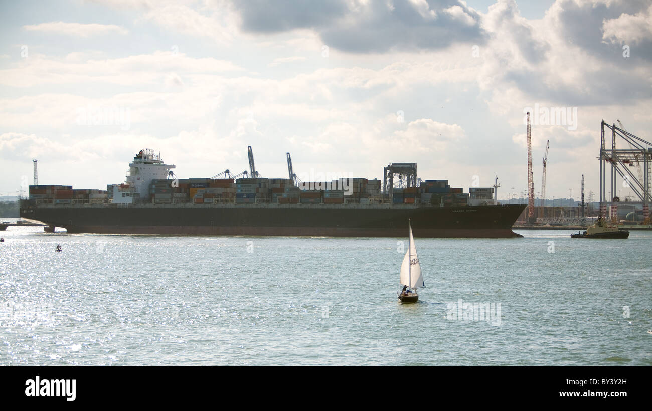 Sailing in the solent,Southampton waters, in the shadow of a berthing container ship 'Maersk Sarnia'. Stock Photo