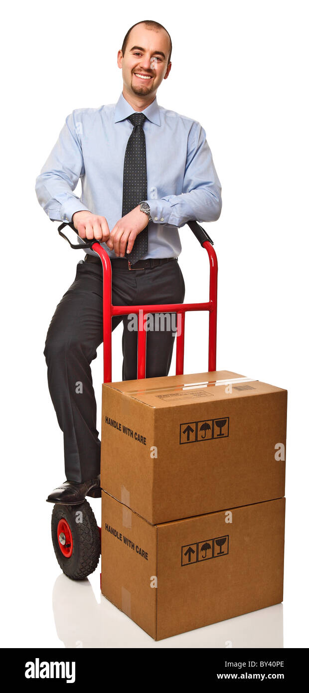 smiling businessman with red handtruck and boxes Stock Photo