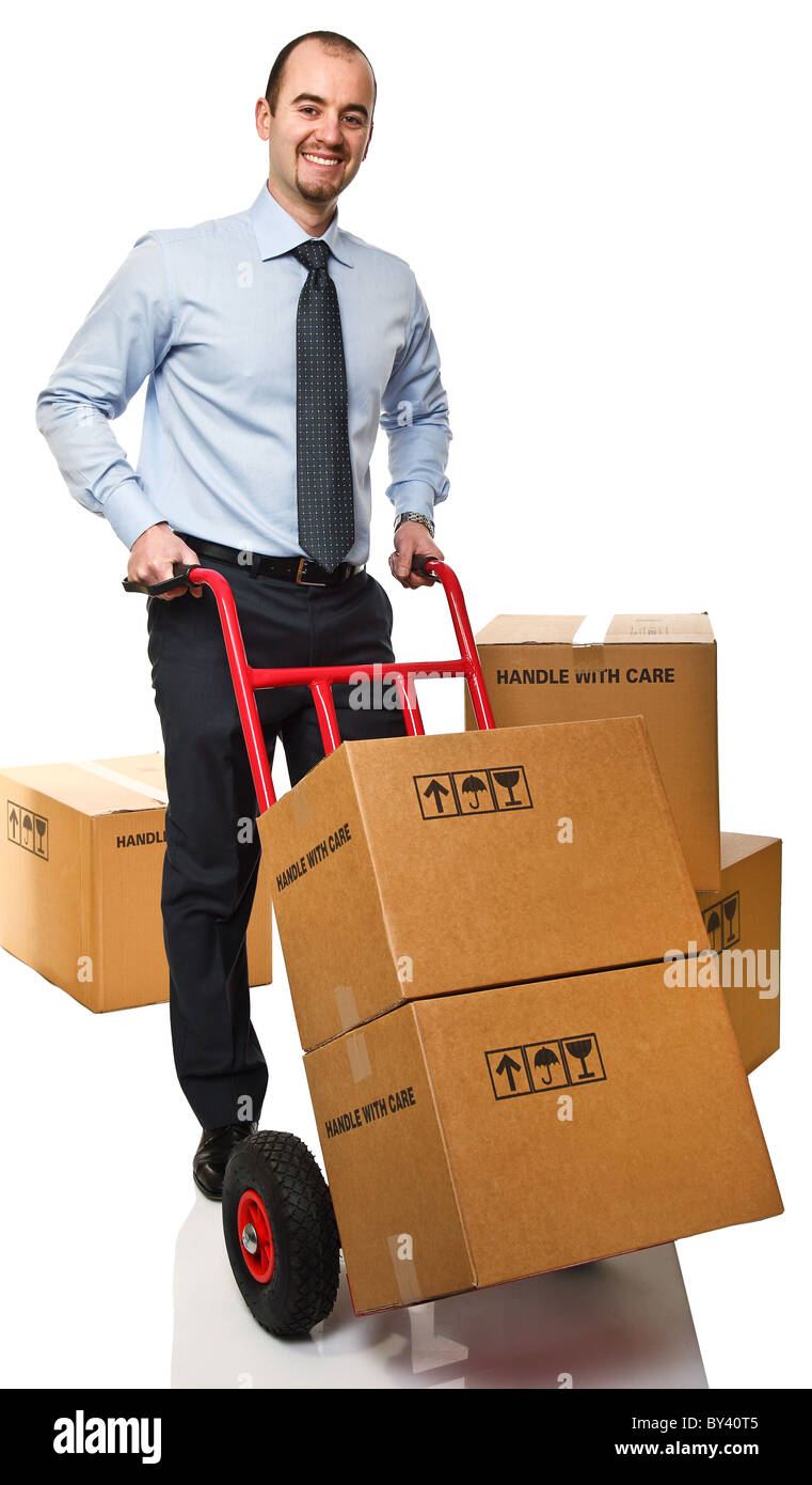 smiling businessman with red handtruck and boxes Stock Photo