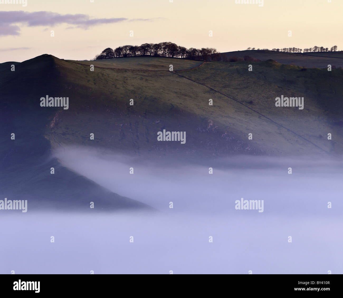 Bunster Hill above a thick veil of autumn mist in Ilam and the Dove valley near Dovedale Stock Photo