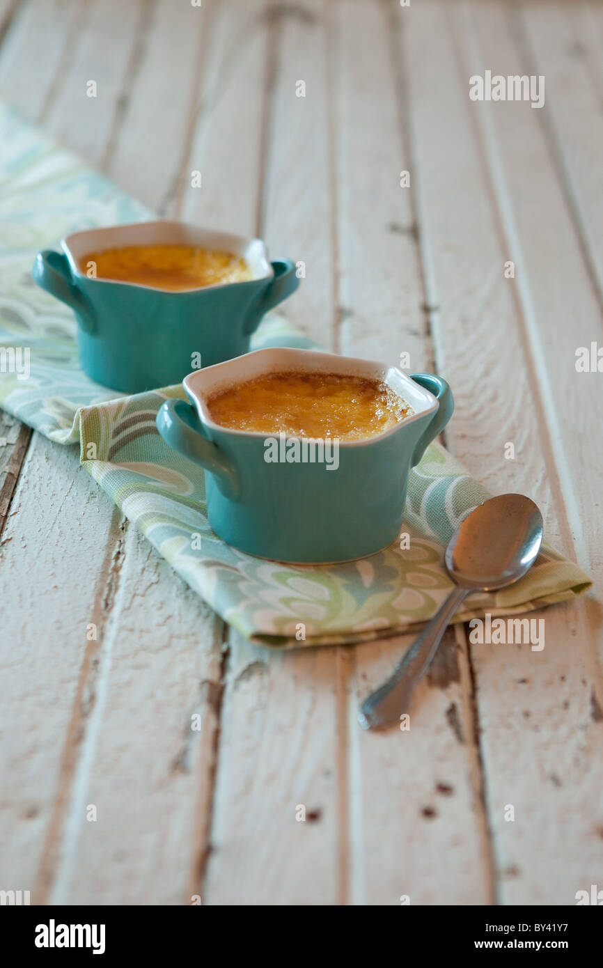 Creme brulee in blue ramekins on a rustic white surface Stock Photo Alamy