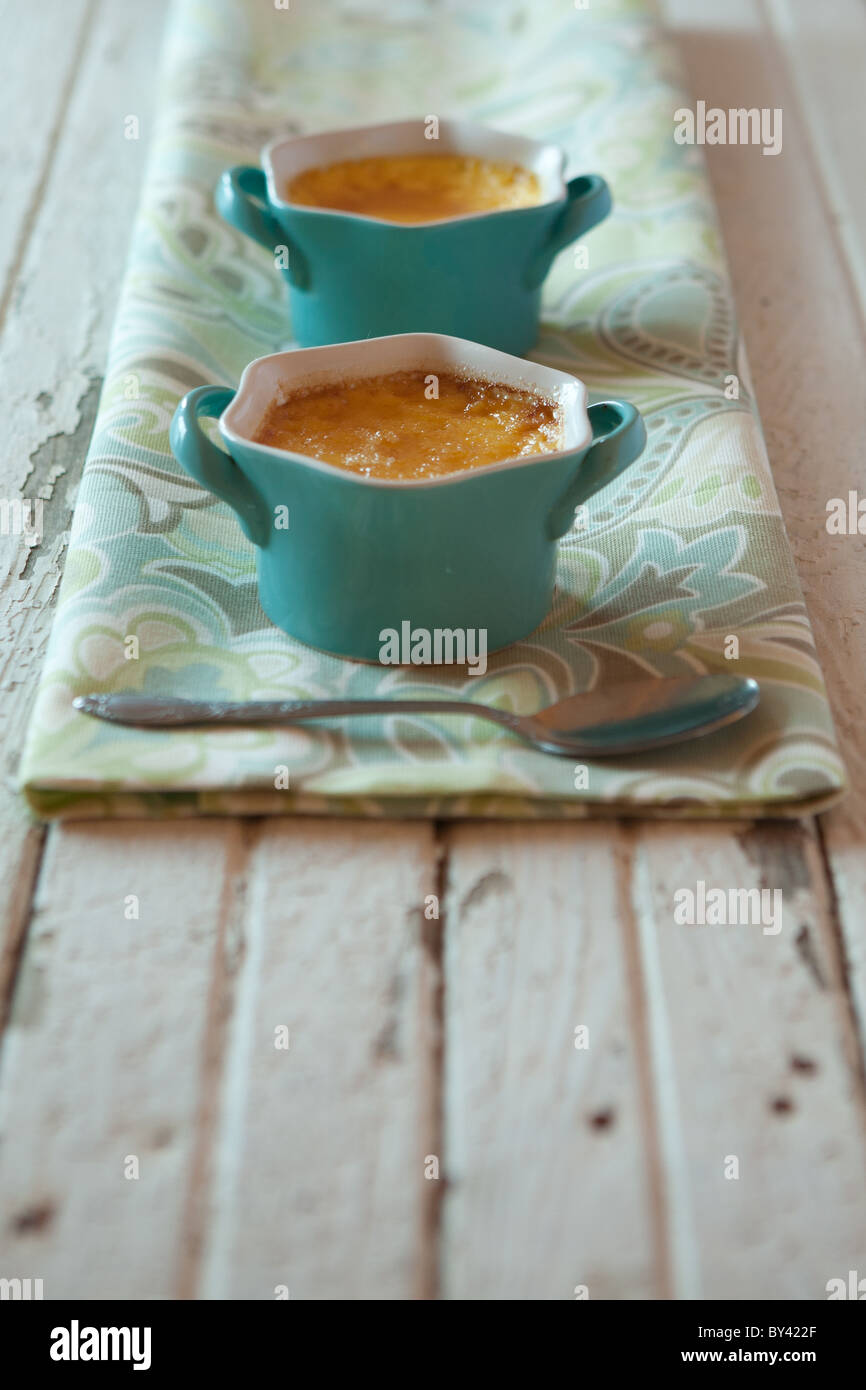 Creme brulee in blue ramekins on a rustic white surface Stock Photo Alamy