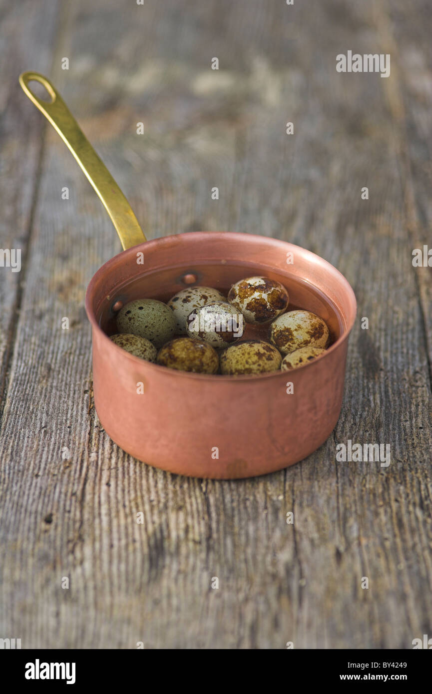 Quails eggs in copper pan on wooden table Stock Photo Alamy