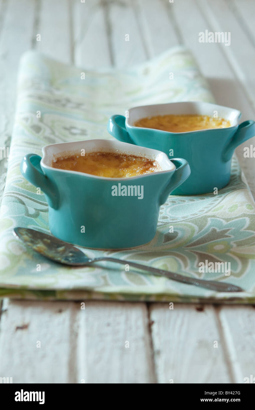 Creme brulee in blue ramekins on a rustic white surface Stock Photo Alamy