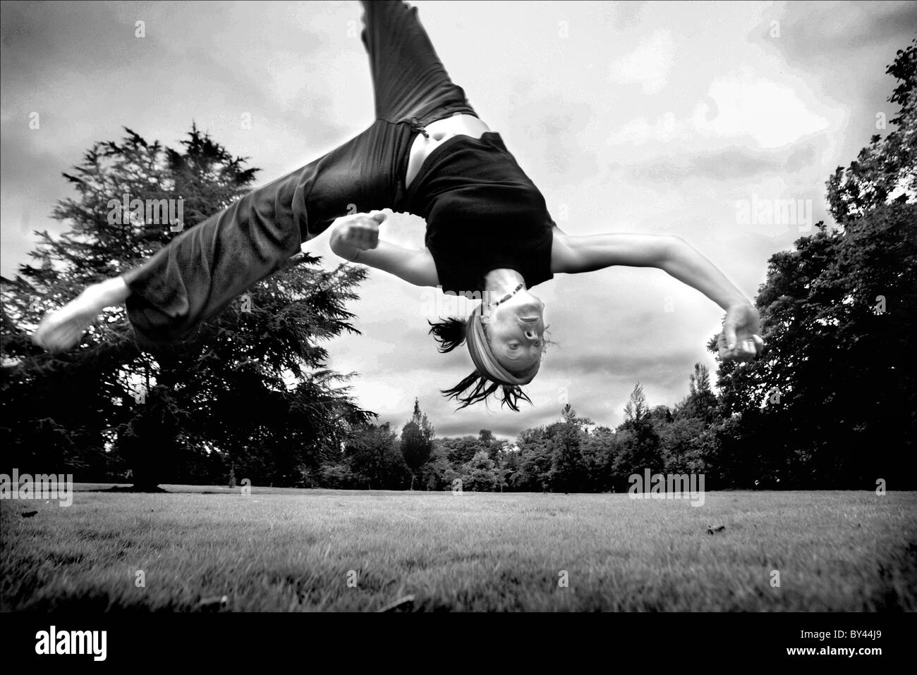 A Gymnast practices Capoera (A Brazilian Martial Art) in Bute Park, Cardiff. Stock Photo