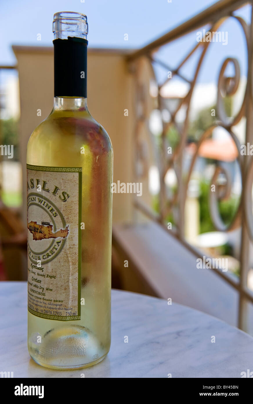 AN OPENED BOTTLE OF WHITE WINE ON A BALCONY TABLE IN CRETE Stock Photo