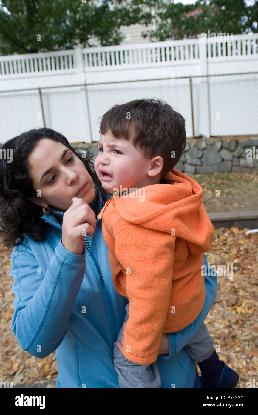Hispanic two year old is comforted by his mother at the playground MODEL RELEASED. Stock Photo