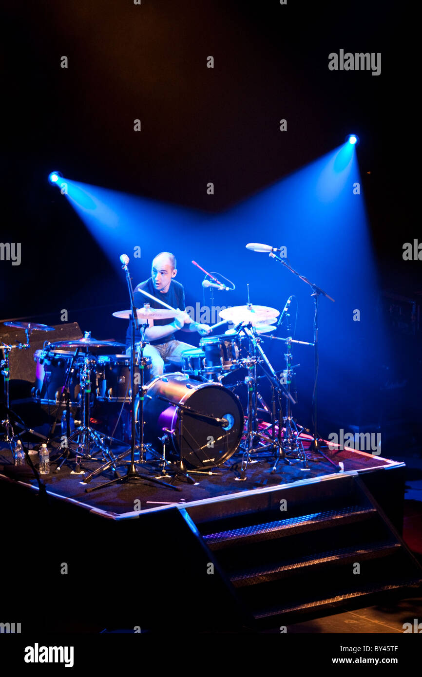 Drummer in rock and roll band on stage under white spotlights in Austin