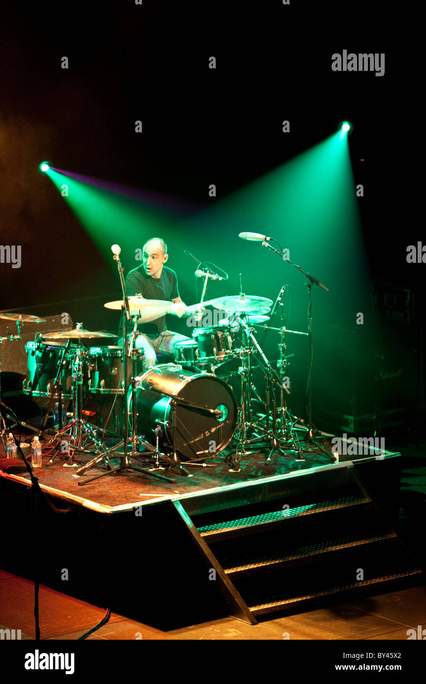 Drummer in rock and roll band on stage under white spotlights in Austin
