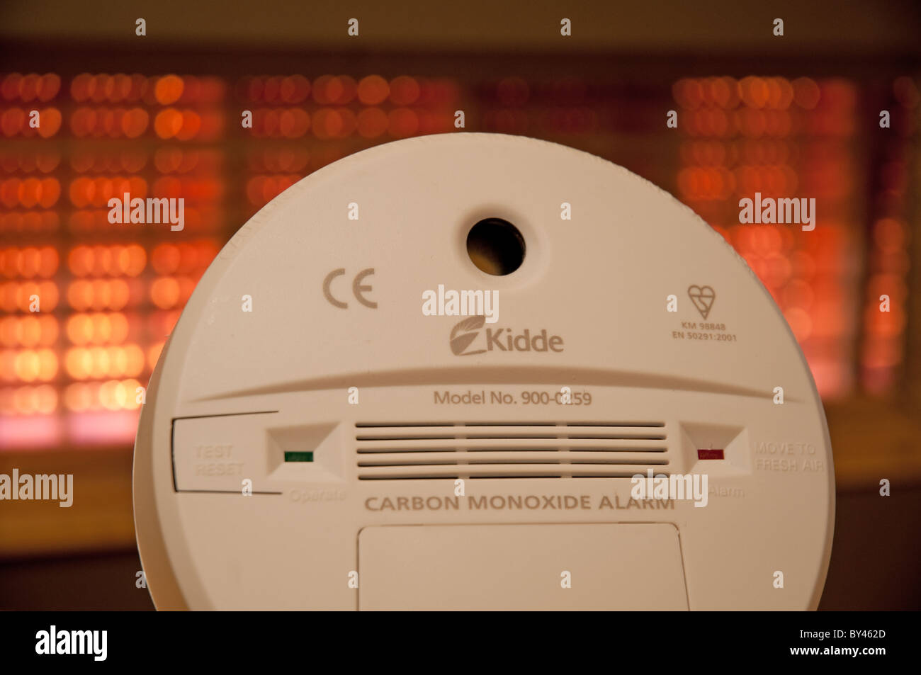 Carbon monoxide alarm against the background of a domestic gas fire. Stock Photo