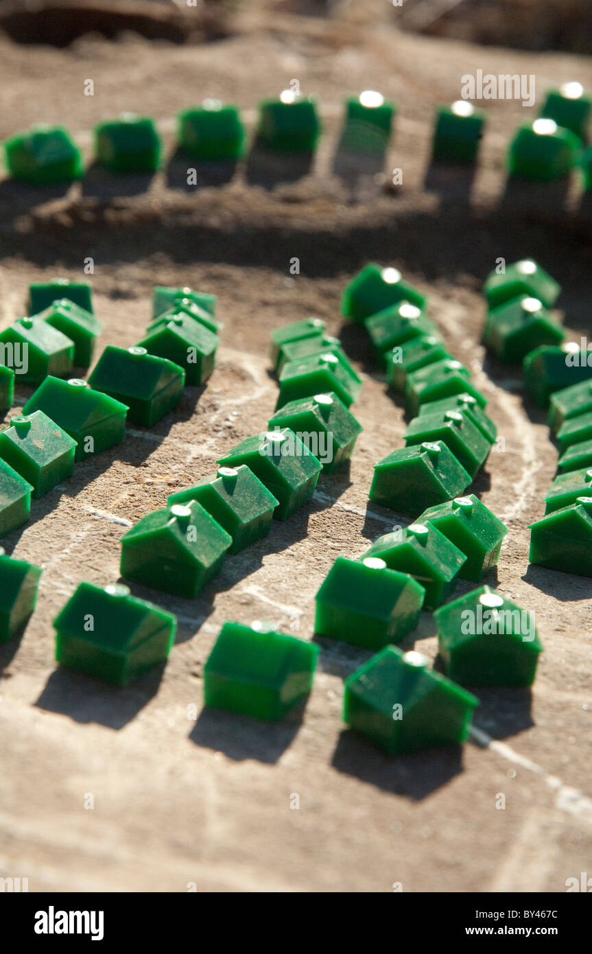 Plastic houses from a popular board game arranged in 'neighborhoods' in the central Texas dirt. Stock Photo