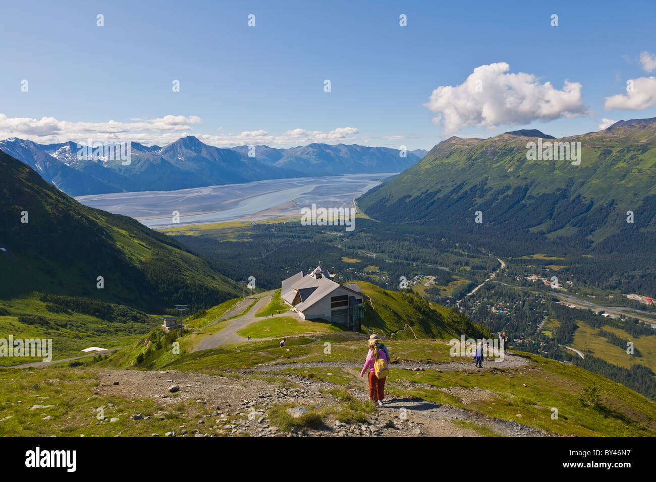 People hiking at the Alyeska Ski Resort in the Chugach Mountains in Girdwood Alaskawith Turnagin Arm in the distance Stock Photo
