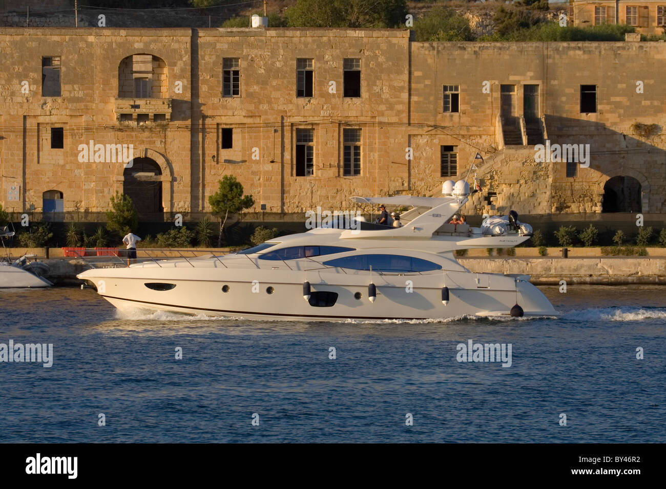 Azimut 68 motor yacht entering Marsamxett harbour in Malta at sunset Stock Photo