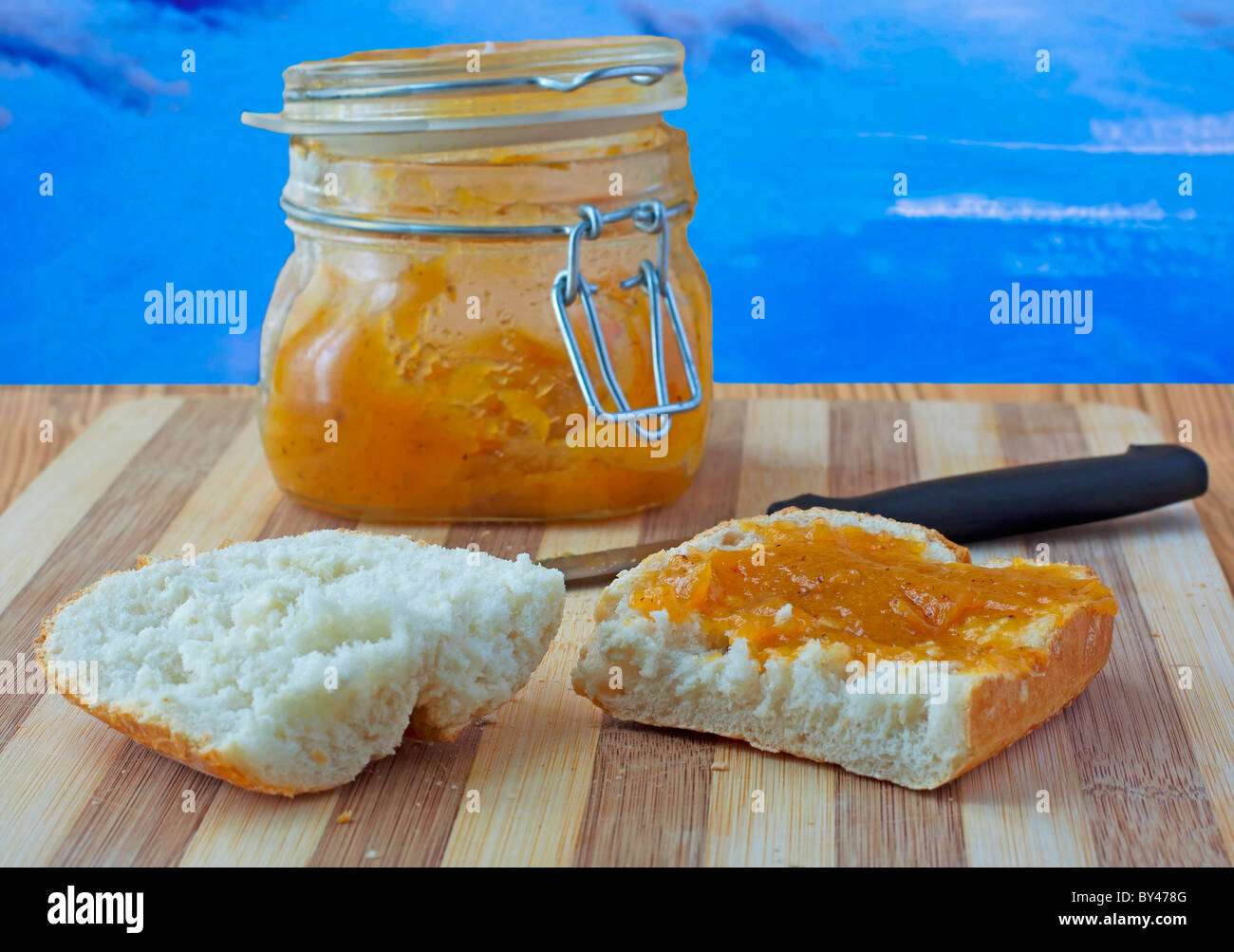Cut bread with orange jam over blue sky Stock Photo