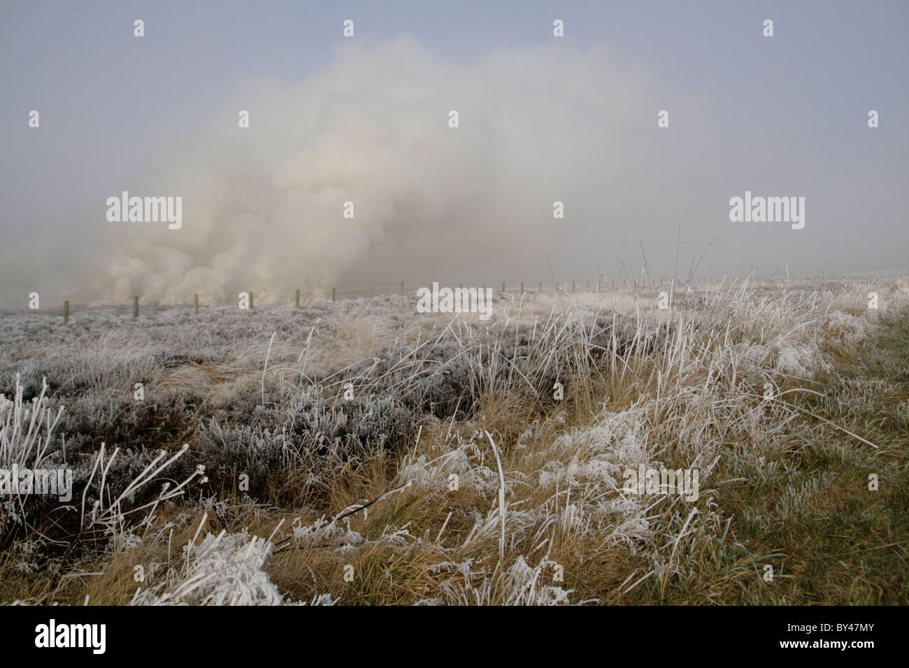 Rising smoke from heather moors burning on a frosty morning on the North York Moors. Stock Photo