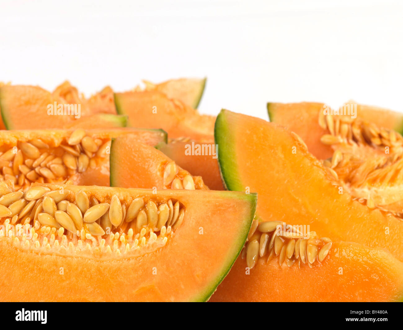 Freshly Cut Segments of A Fresh Healthy Orange Cantaloupe Melon In Close Up Against A White Background With Copy Space And No People Stock Photo