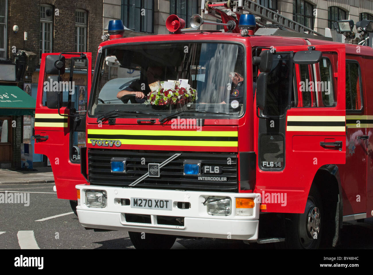 Wreath in cab window of Volvo fire engine at National firefighters memorial Service of remembrance. Stock Photo