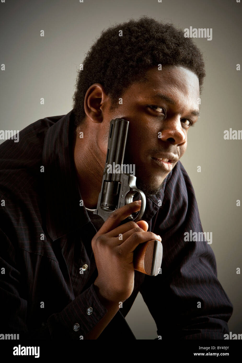 Young black male model posing with a gun Stock Photo