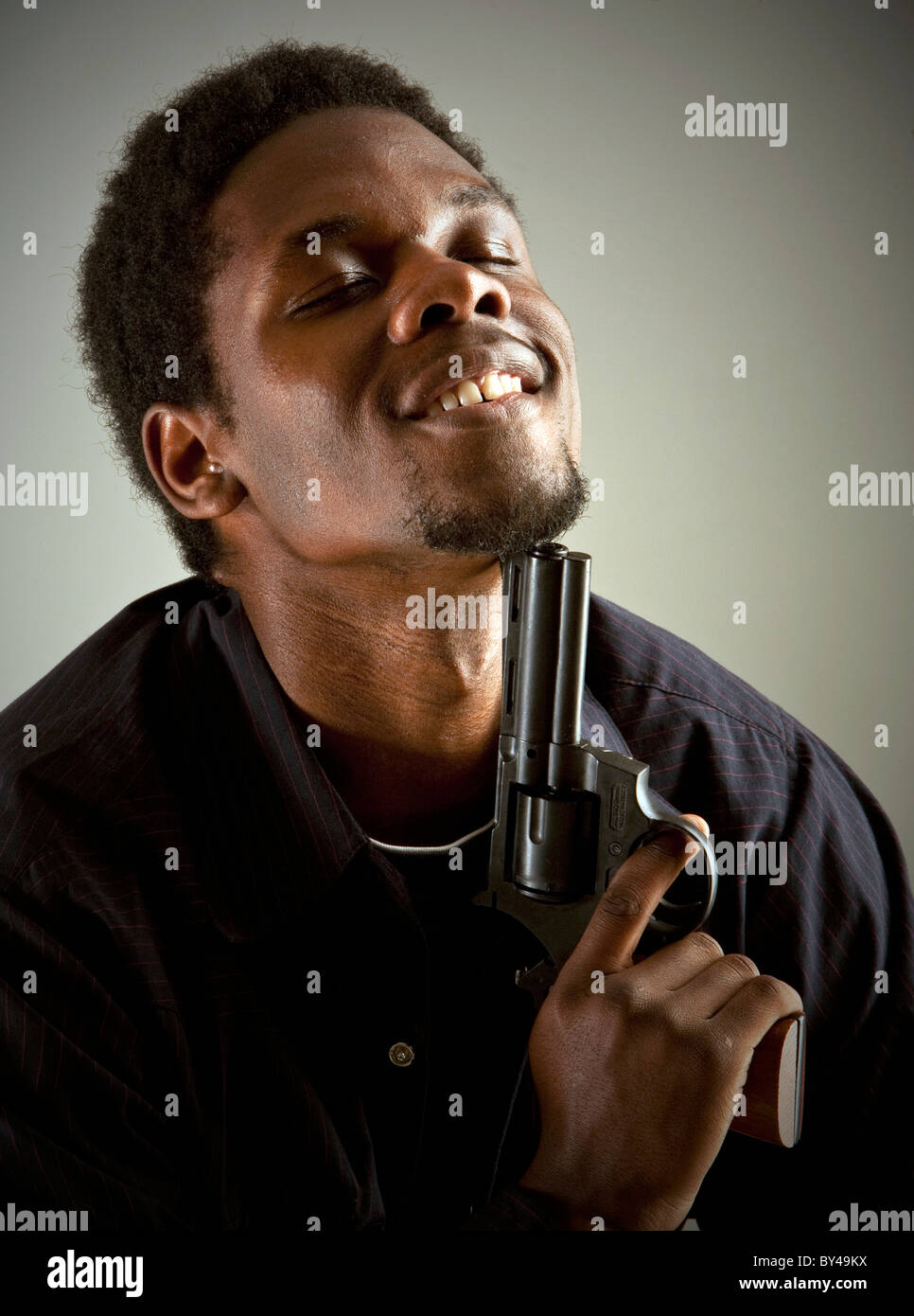 Young black male model posing with a gun Stock Photo