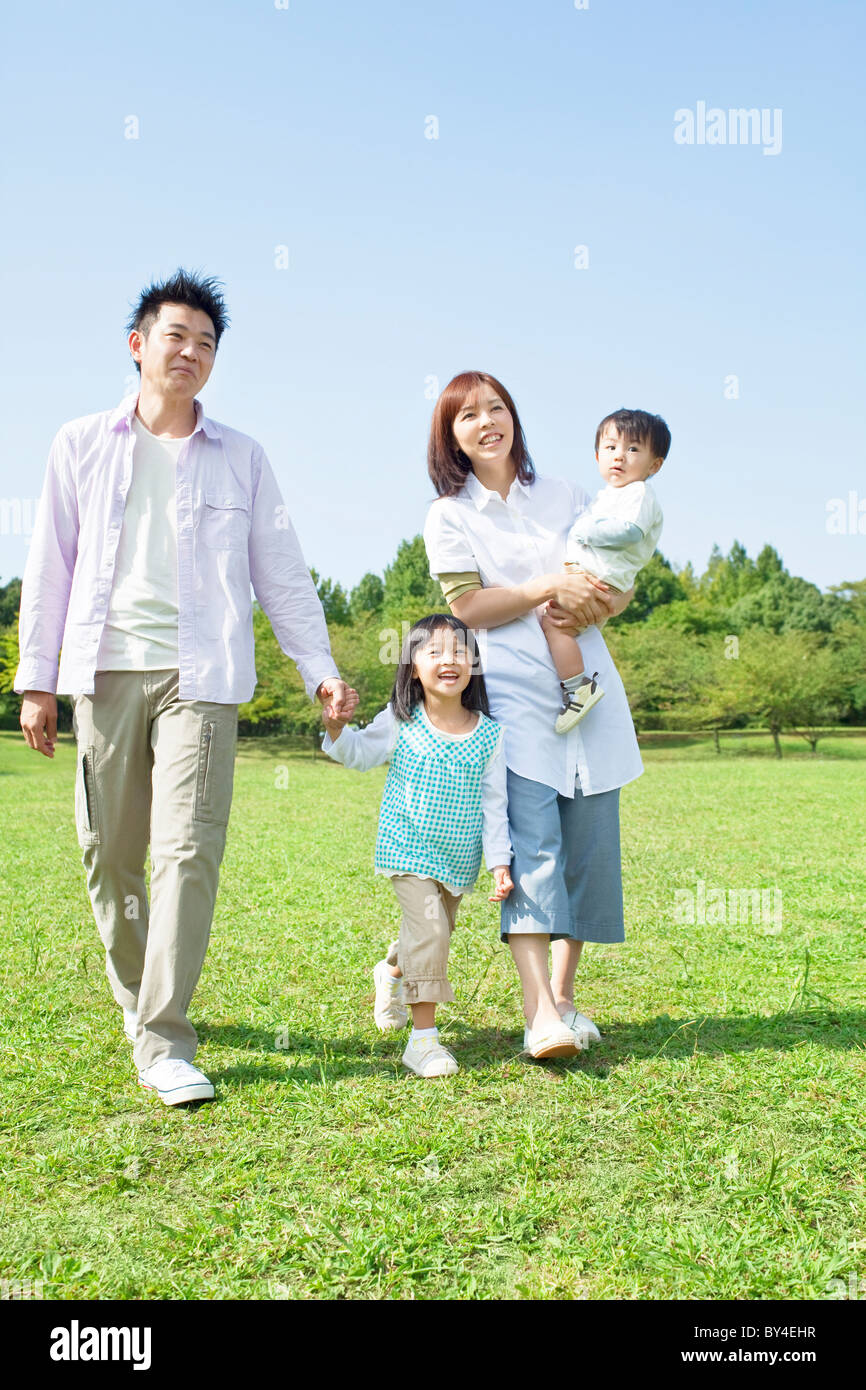 Family walking on grass Stock Photo