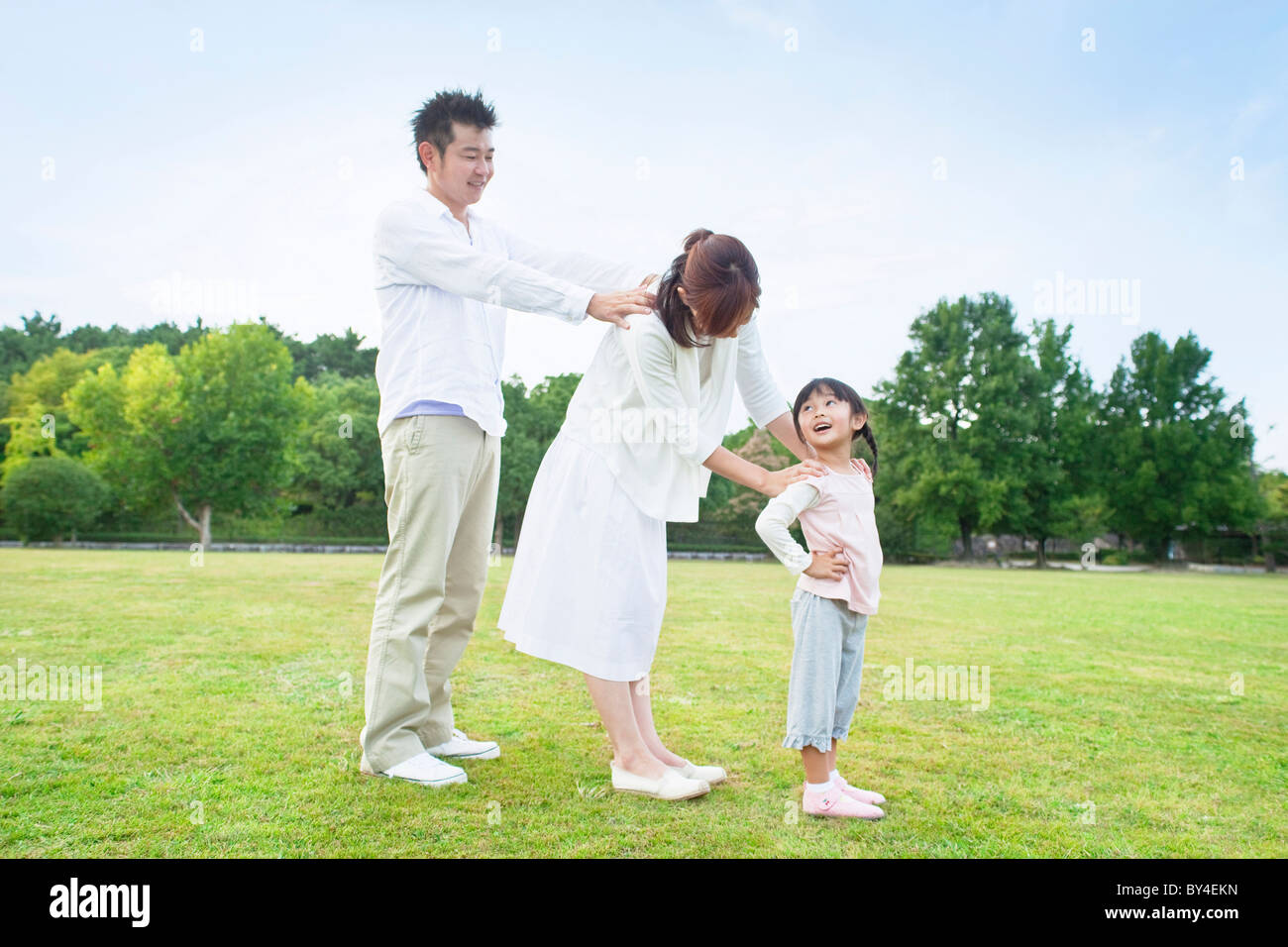 Family with hands on shoulders standing in a row Stock Photo