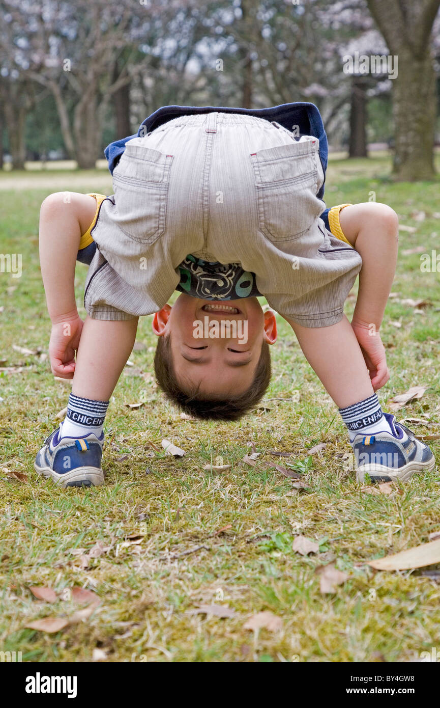 Boy Looking at Camera Between His Legs Stock Photo