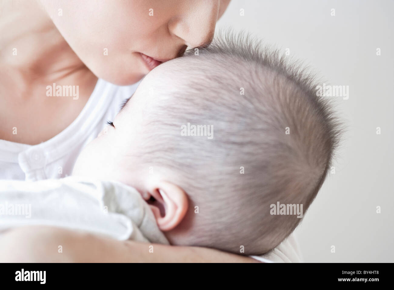 Mother kissing a baby boy Stock Photo Alamy