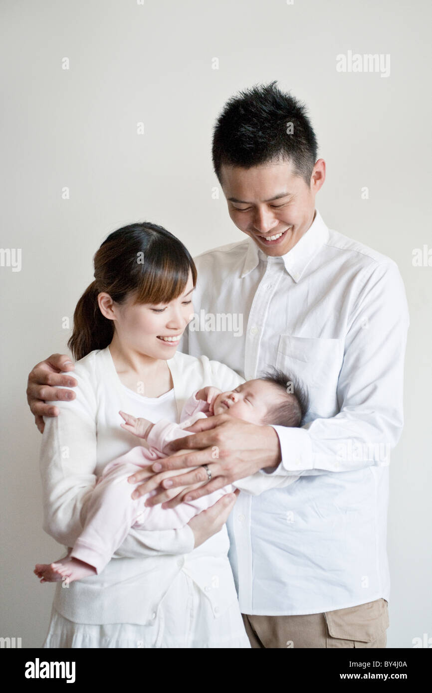 Family standing and looking at baby Stock Photo