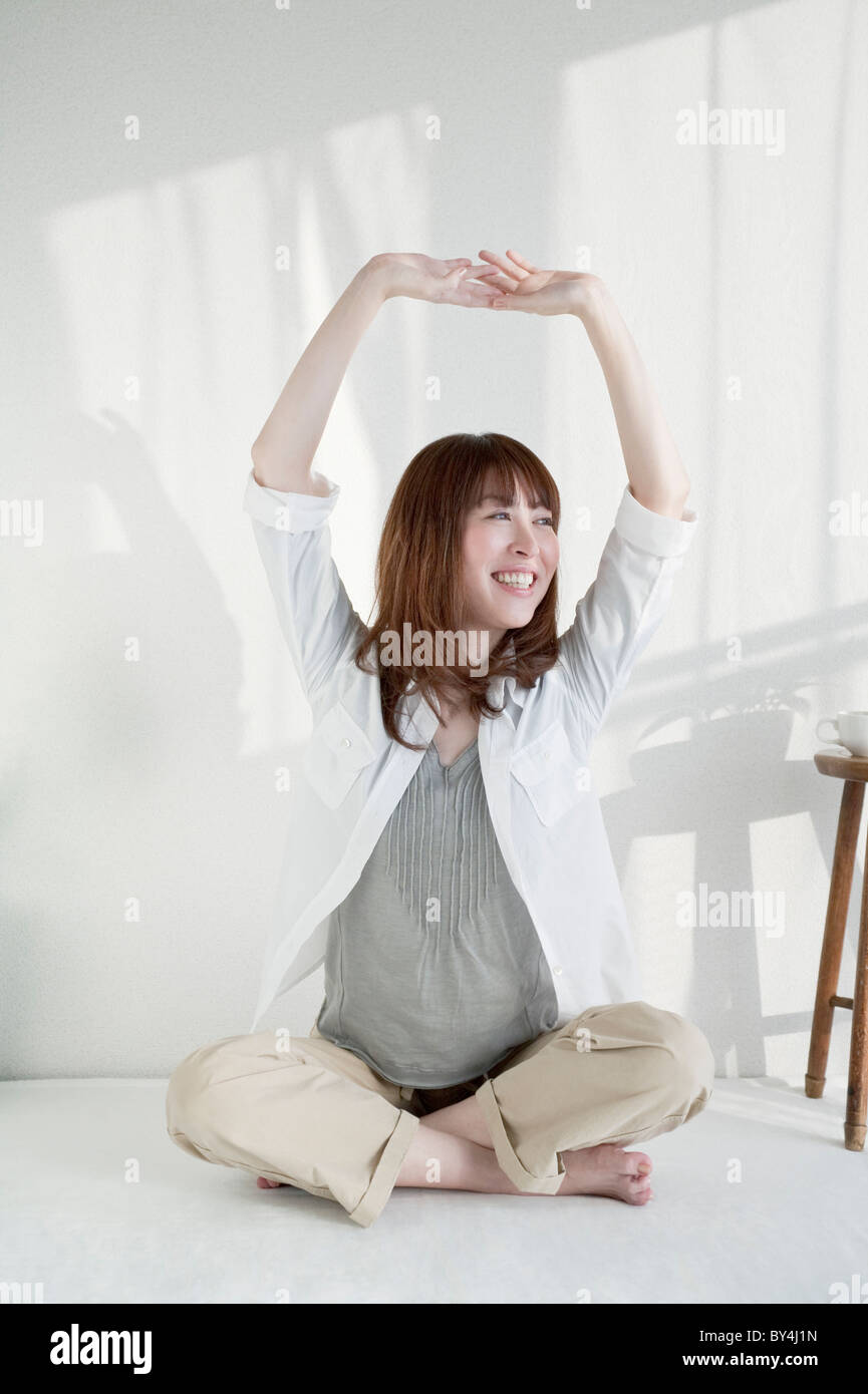 Woman sitting on floor stretching Stock Photo - Alamy