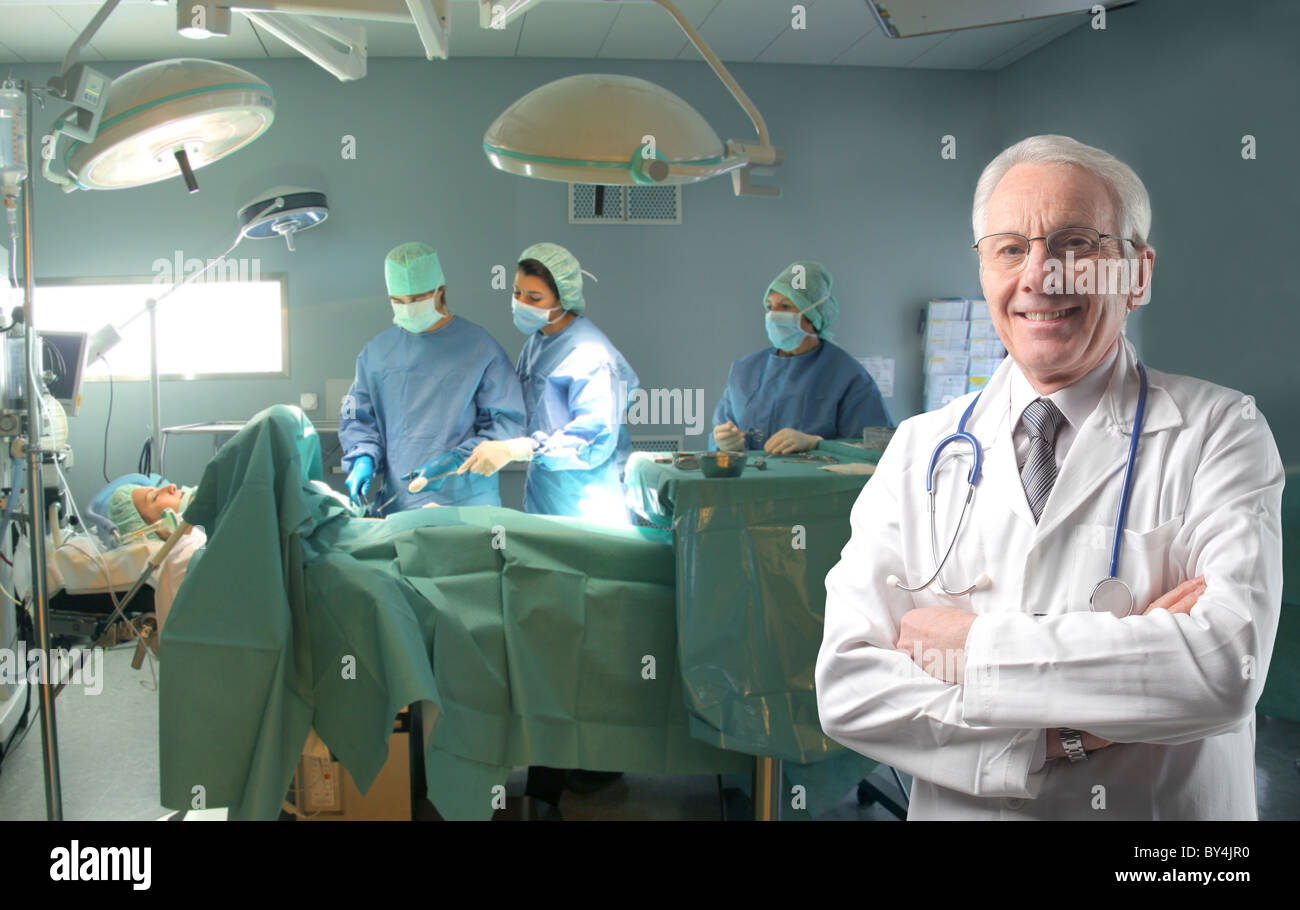 Old doctor staying in an operating room during a surgery Stock Photo