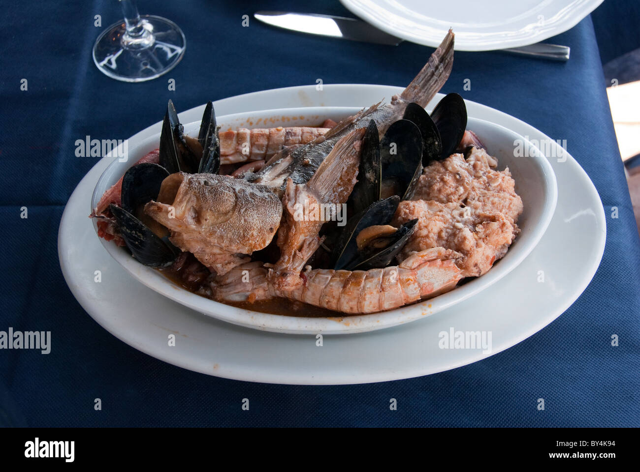 Livorno fish stew known as “Cacciucco” containing five different kinds of fish served in a soup dish Stock Photo