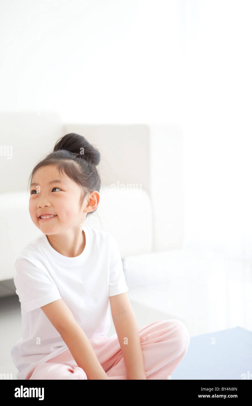 Girl Sitting Crosslegged on Floor Stock Photo Alamy