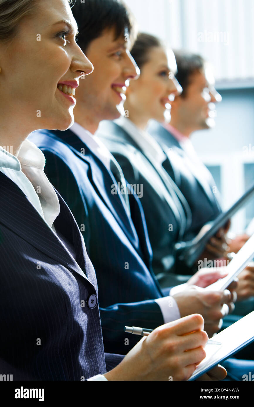 Row of successful business people listening to the teacher at seminar Stock Photo
