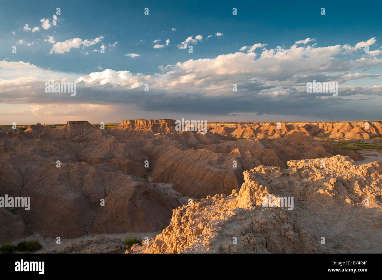 A storm rolls in over the plateaus of Badlands National Park at dusk Stock Photo